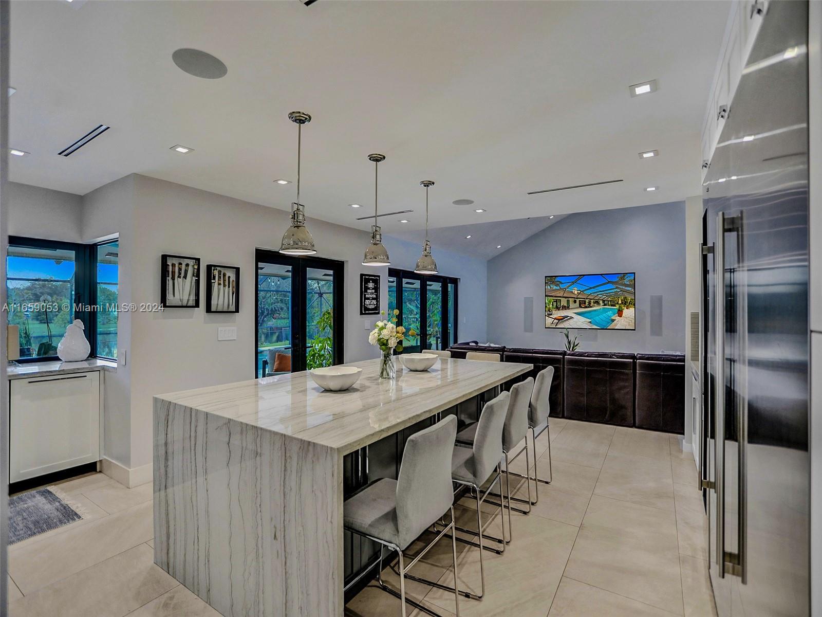 20221 Southwest 48th Place Southwest Ranches, FL 33332 - Photo 41 of 42 a kitchen with kitchen island granite countertop a stove a refrigerator a oven a sink a dining table and chairs with wooden floor