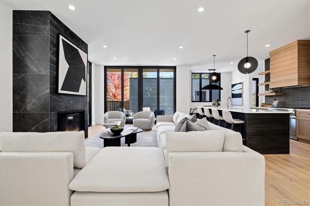 a living room with fireplace furniture and a large window