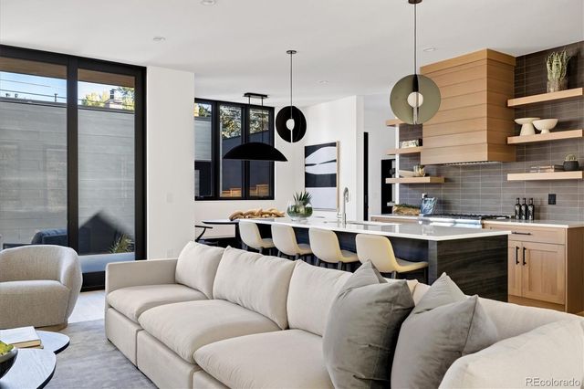 a living room with furniture kitchen view and a window
