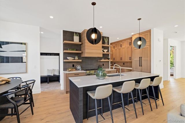 a kitchen with a dining table chairs stainless steel appliances and cabinets