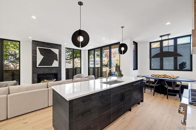 a living room with stainless steel appliances kitchen island furniture and a large window