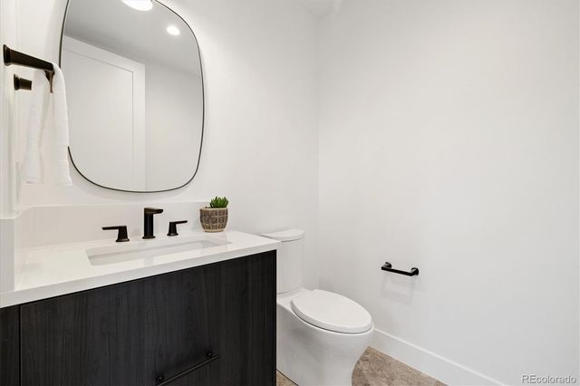 a bathroom with a sink vanity mirror and toilet