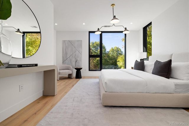 a bedroom with a bed a mirror and window