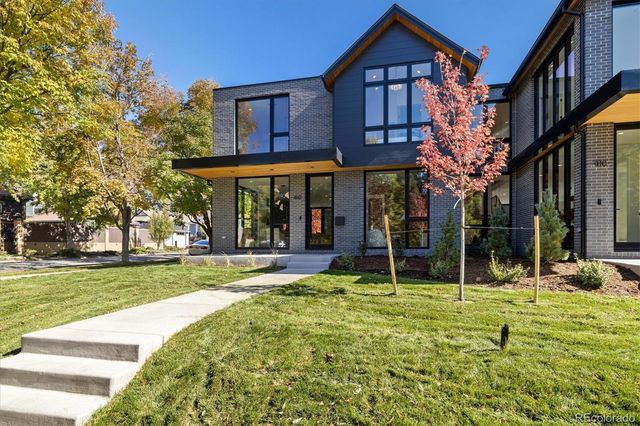 a view of a house with a big yard and large trees