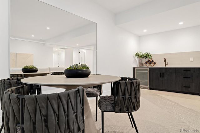 a kitchen with stainless steel appliances a table and chairs in it