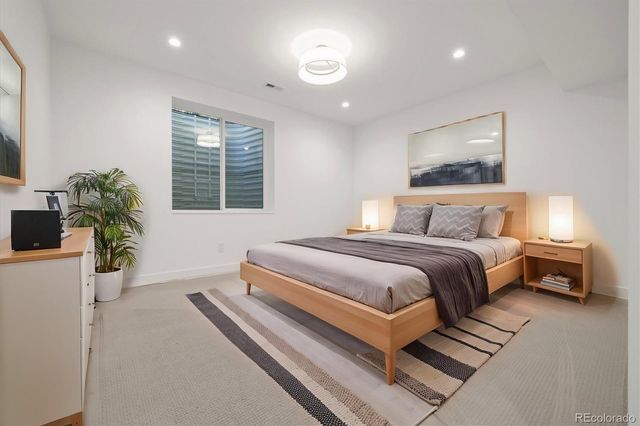 a bedroom with a large bed and a potted plant