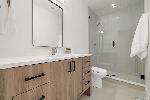 a bathroom with a double vanity sink toilet and shower