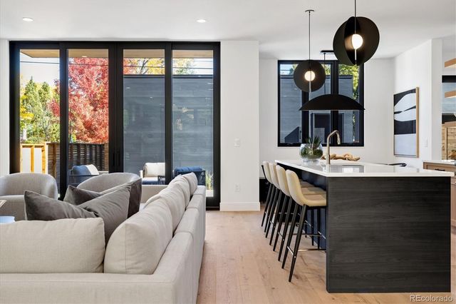 a living room with furniture a floor to ceiling window and a flat screen tv