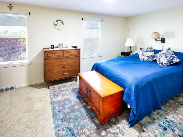 a room with a bed and dresser