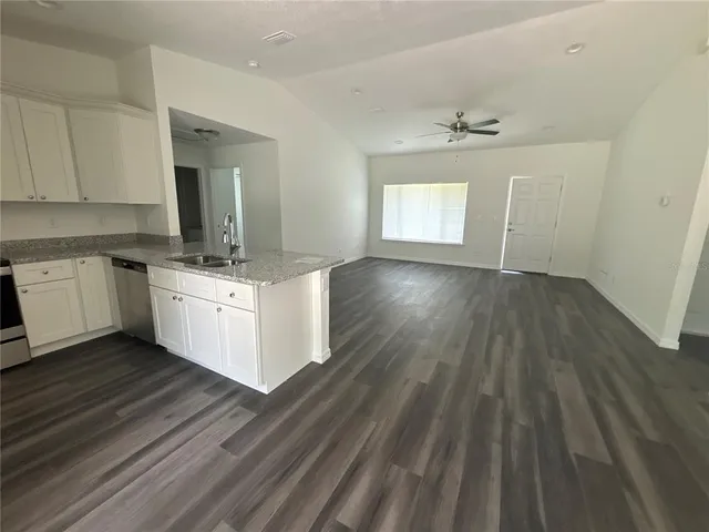 a kitchen with granite countertop a refrigerator and a sink