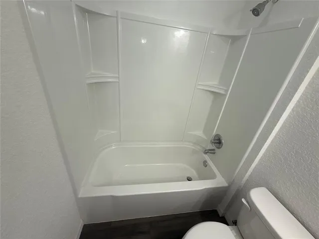 a bathroom with a bathtub and toilet