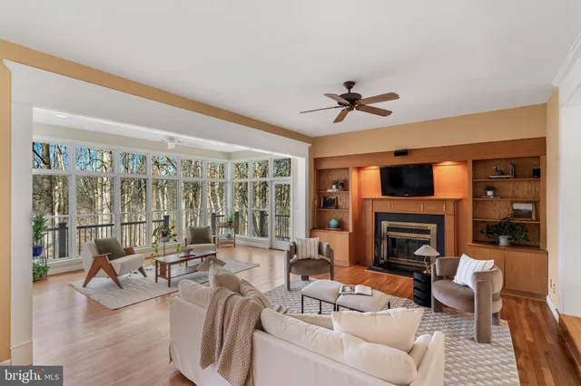 a living room with furniture large window and wooden floor