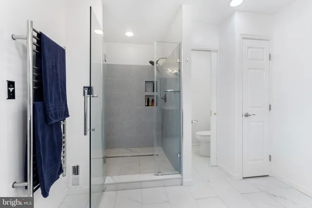 a bathroom with a granite countertop sink a toilet and shower