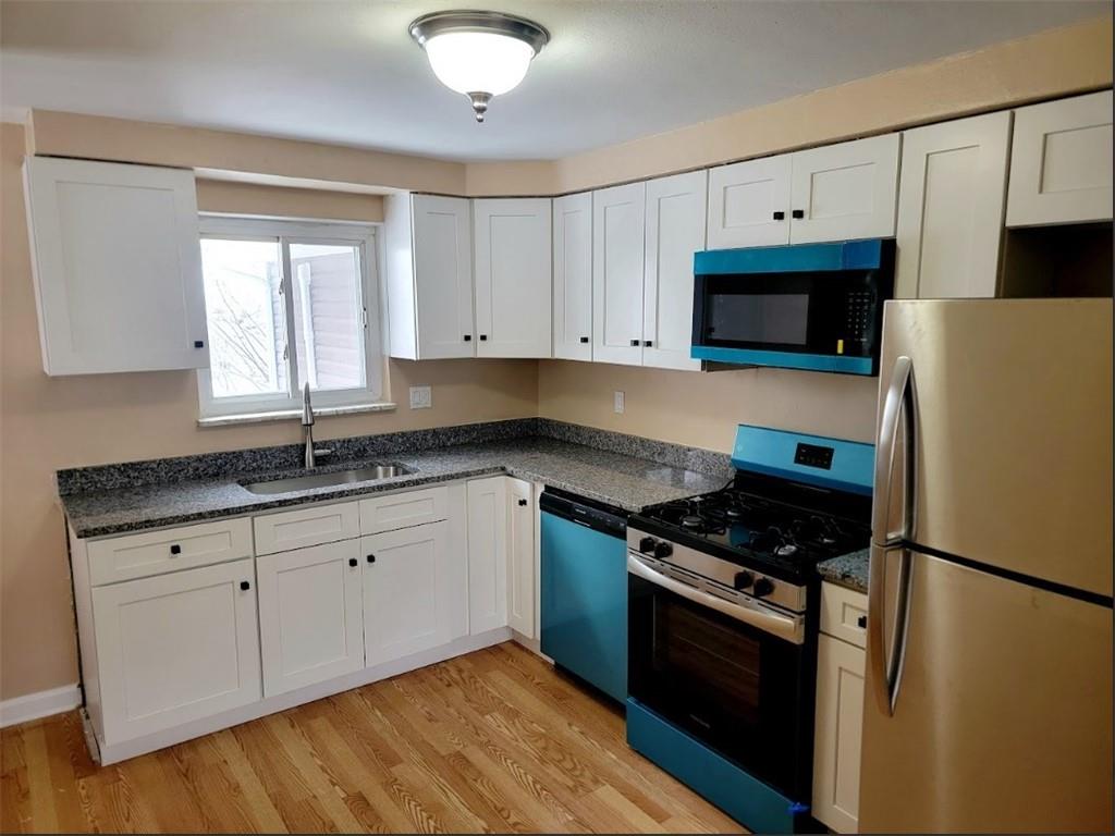 710 Parkwood Road Pittsburgh, PA 15210 - Photo 6 of 17 a kitchen with granite countertop a refrigerator stove top oven and sink