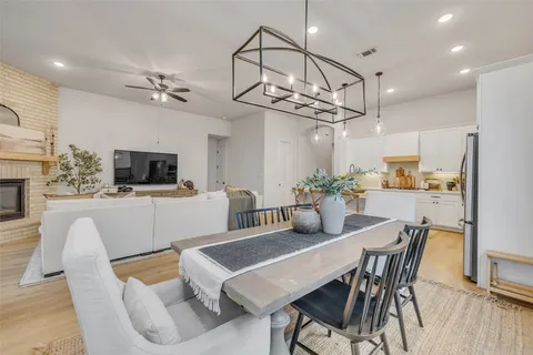 a view of a dining room with furniture a kitchen and chandelier