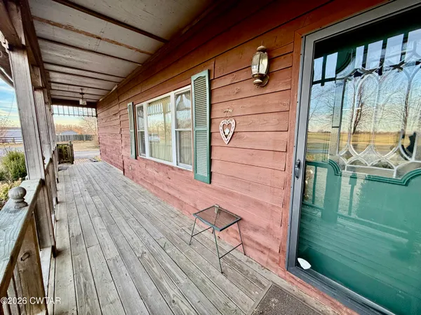 a view of a porch with wooden floor and outdoor seating