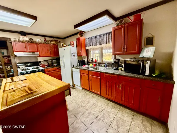 a kitchen with stainless steel appliances kitchen island granite countertop a refrigerator stove top oven and sink