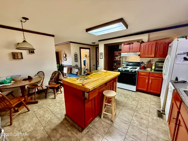 a kitchen with a stove a sink dishwasher and a dining table with the kitchen view