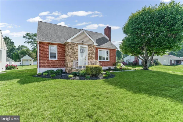 a front view of a house with a yard and trees