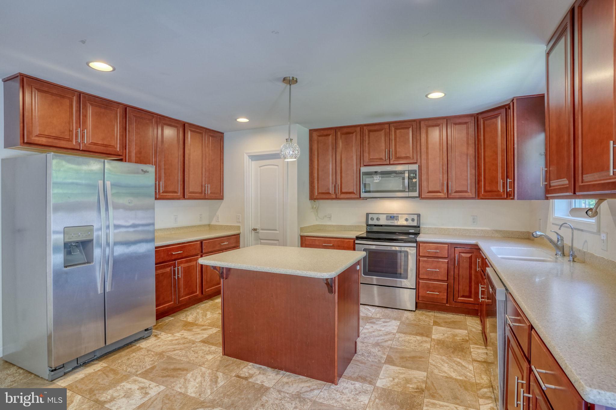 a kitchen with stainless steel appliances granite countertop a refrigerator stove a sink and dishwasher