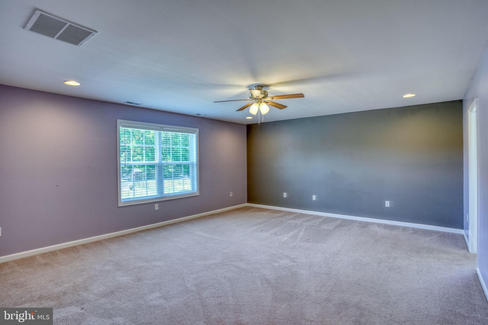 107 Hunters Run Magnolia, DE 19962 - Photo 17 of 41 an empty room with a chandelier fan and windows