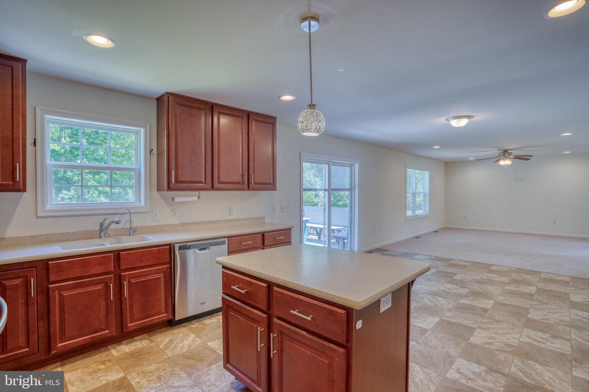 107 Hunters Run Magnolia, DE 19962 - Photo 5 of 41 a kitchen that has a sink a microwave oven a stove and white cabinets with wooden floor