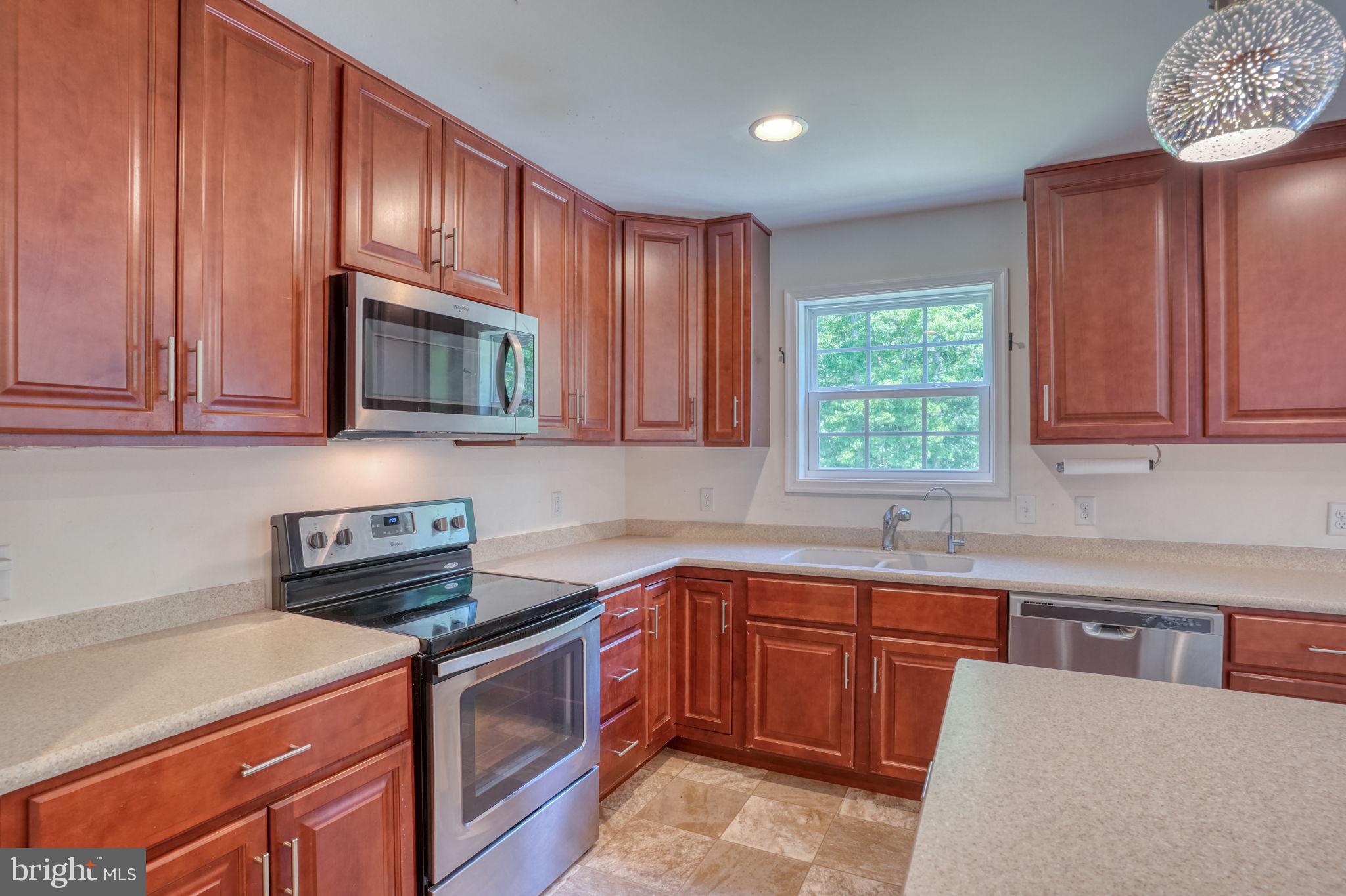 107 Hunters Run Magnolia, DE 19962 - Photo 6 of 41 a kitchen with stainless steel appliances granite countertop a stove a sink dishwasher and a microwave oven with cabinets