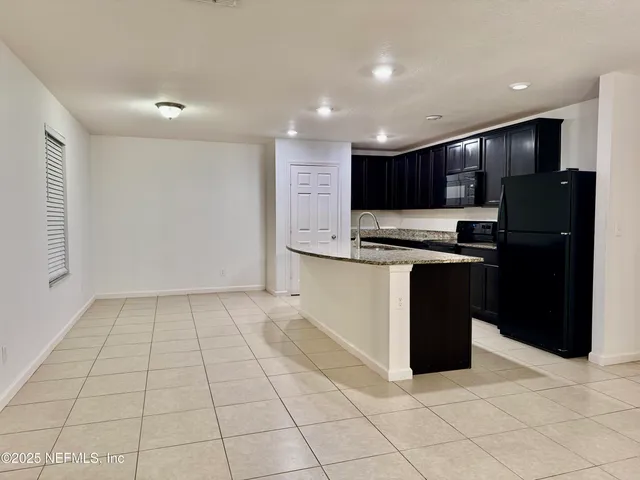 a kitchen with stainless steel appliances granite countertop a refrigerator and a stove