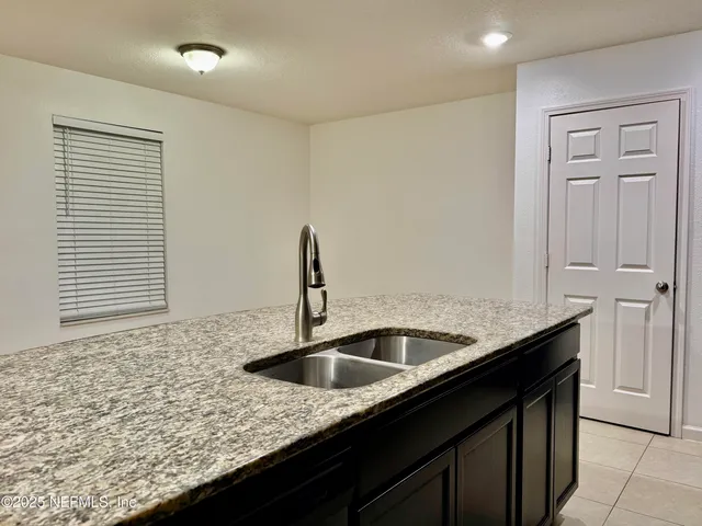 a kitchen with granite countertop a sink and cabinets