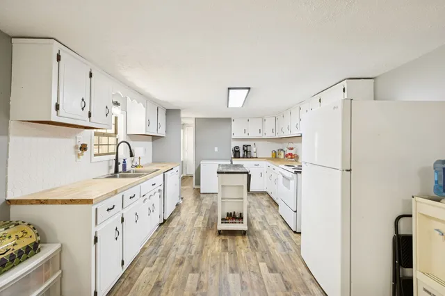 a kitchen with white cabinets and white appliances