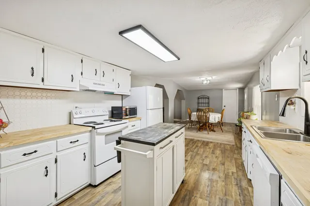 a kitchen with cabinets appliances a sink and a counter top space