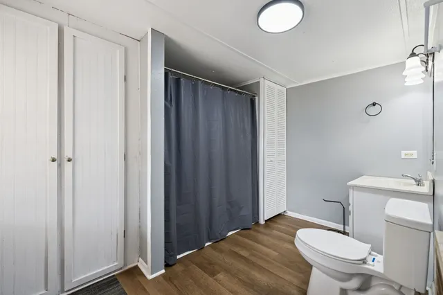 a bathroom with a granite countertop toilet and a sink