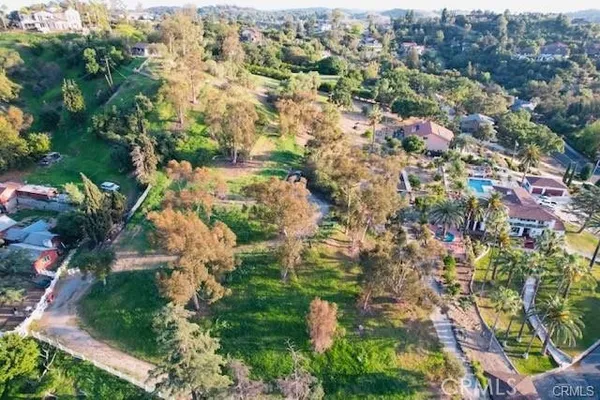 an aerial view of residential houses with outdoor space and trees