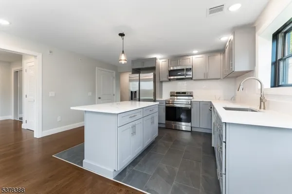 a large kitchen with kitchen island a sink stainless steel appliances and cabinets