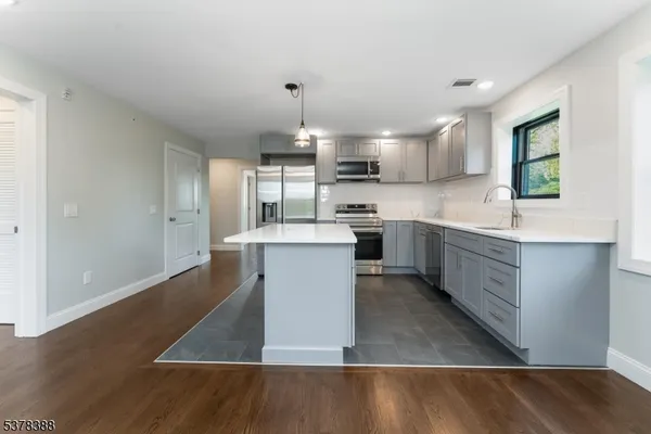 a kitchen with stainless steel appliances kitchen island wooden cabinets and granite counter tops