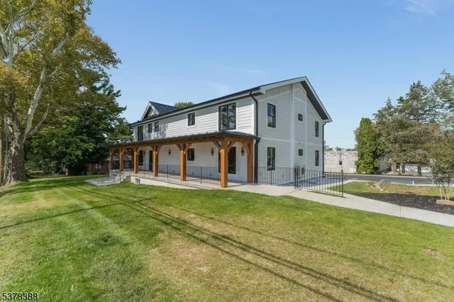 a front view of a house with a yard and trees