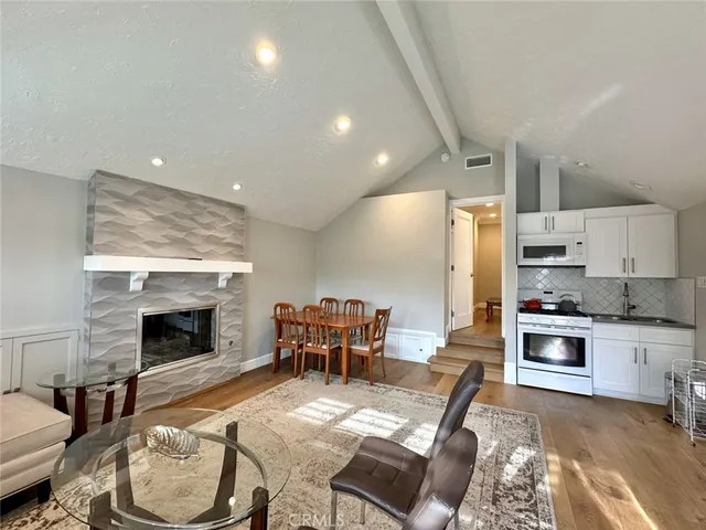 a living room with furniture a fireplace and kitchen view