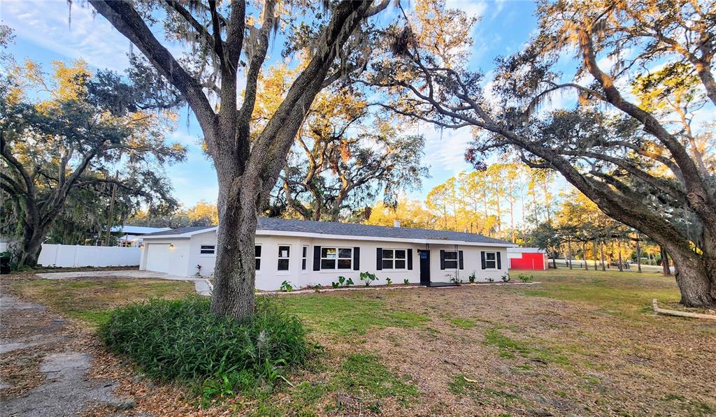 3720 Willis Road Mulberry, FL 33860 - Photo 1 of 1 a front view of a house with large trees and a big yard