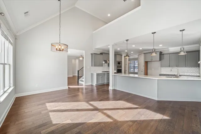 a large white kitchen with lots of counter space wooden floor and appliances
