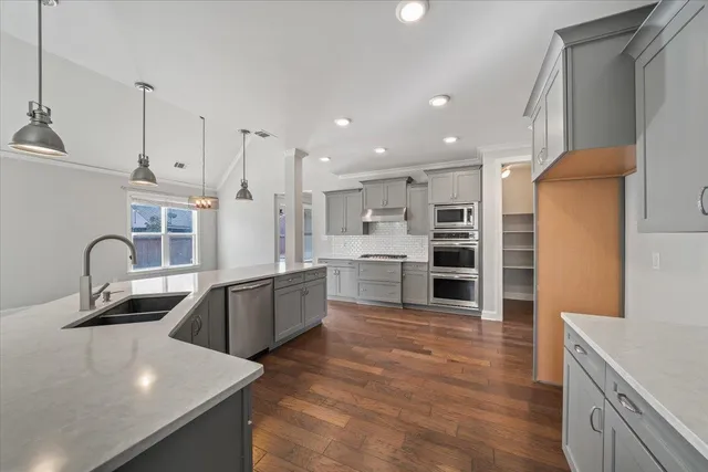 a kitchen with stainless steel appliances granite countertop a sink refrigerator and cabinets