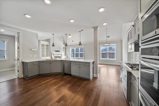 a large kitchen with a wooden floor and stainless steel appliances