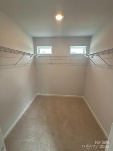 an empty room with windows and white walls