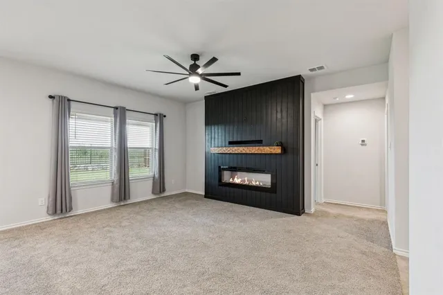 a view of an empty room with a fireplace and a window