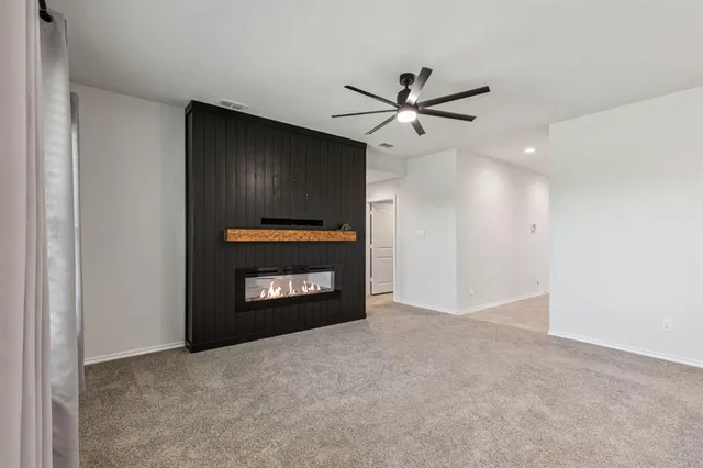 a view of an empty room with a fireplace and a window