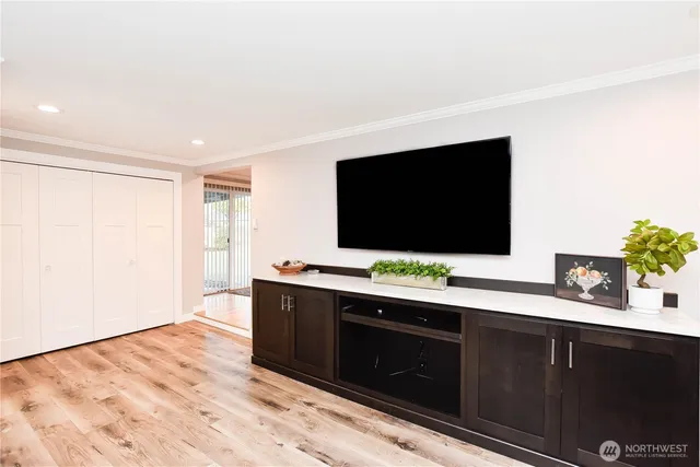a living room with a flat screen tv furniture and a potted plant