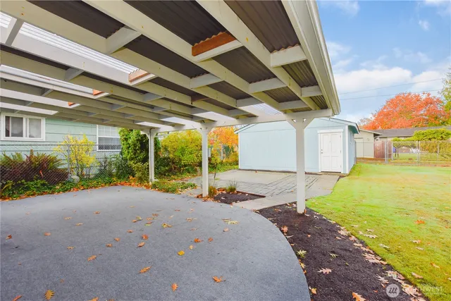 a view of a backyard with table and chairs under an umbrella