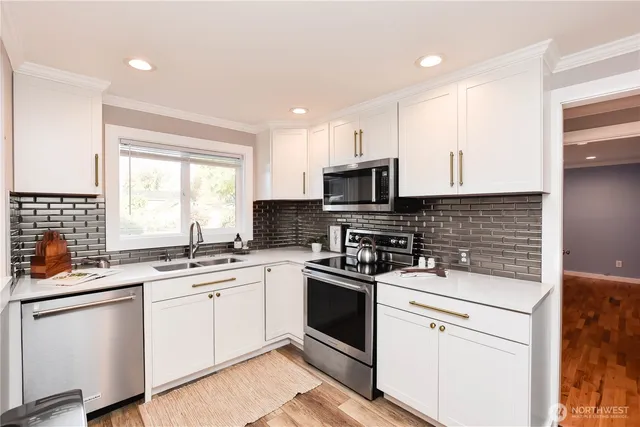 a kitchen with a sink stove and white cabinets