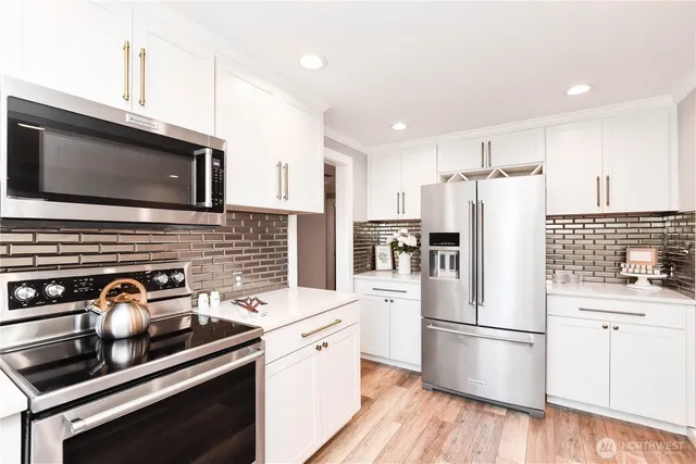 a kitchen with stainless steel appliances a refrigerator stove and sink