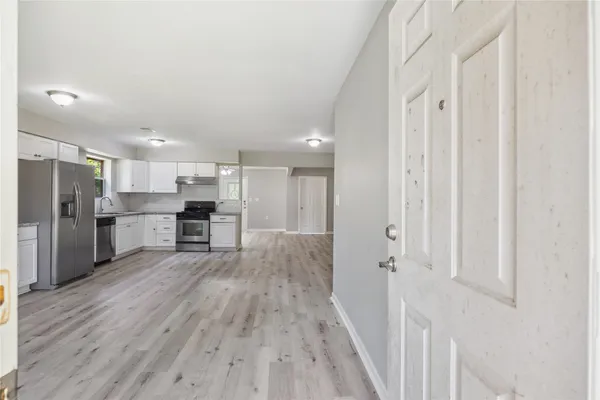 a kitchen with stainless steel appliances refrigerator wooden floor and cabinets