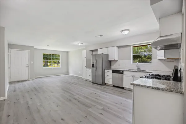 a kitchen with stainless steel appliances granite countertop a stove a sink and a refrigerator